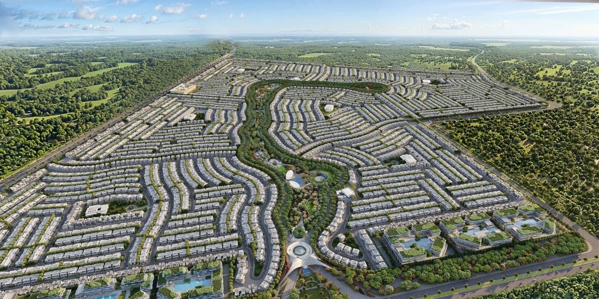 Aerial view of the Azizi Florence master plan in Sharjah, showing villa and townhouse clusters wrapped around a central green spine.